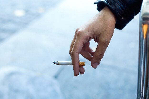 Womans strony z papierosem na ulicy.