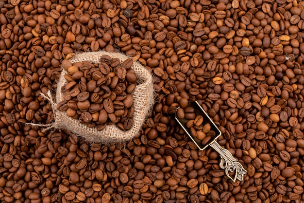 Bezpłatne zdjęcie worek pełen ziaren kawy na powierzchni ziaren kawy