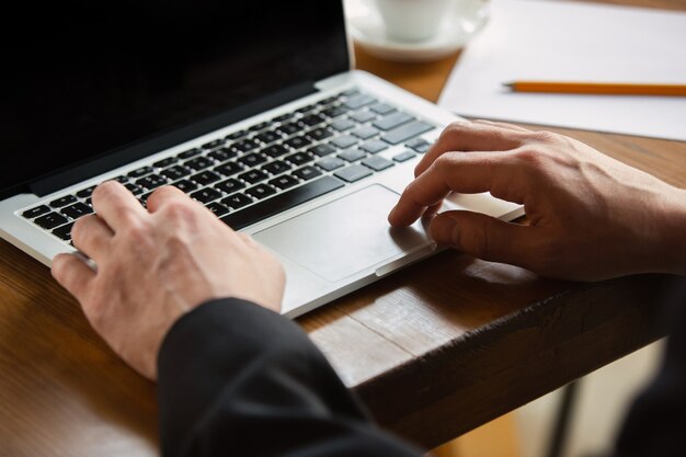 Wpisywanie tekstu. Zbliżenie na kaukaski męskich rąk, pracujących w biurze. Pojęcie biznesu, finansów, pracy, zakupów online lub sprzedaży. Miejsce na reklamę. Edukacja, komunikacja niezależna.