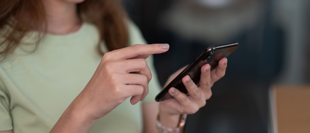 Wskaż palec na ekranie telefonu komórkowego zbliżenie, osoba wysyłanie sms-ów wiadomości tekstowe dziewczyny za pomocą w rękach telefon z bliska, internet online.