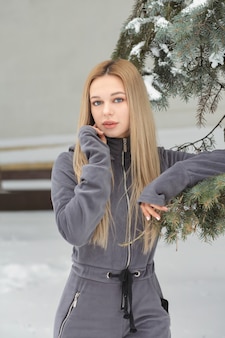 Wspaniała kobieta z długimi włosami pozuje w lesie zimą
