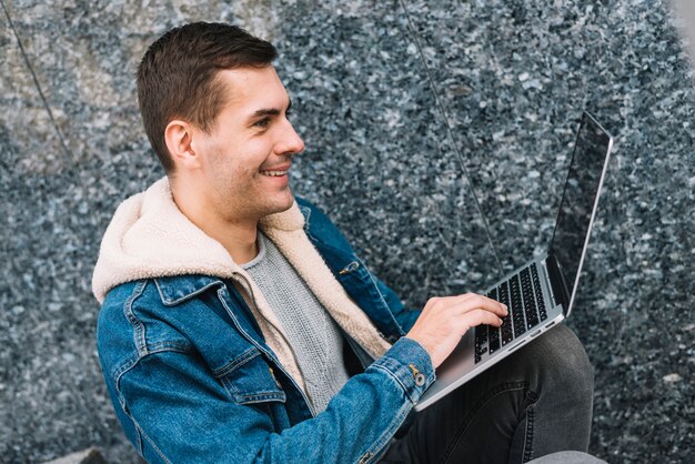 Współczesny człowiek za pomocą laptopa w środowisku miejskim