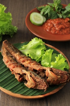 Wybrany focus lele goreng lub smażony sum to tradycyjna indonezyjska potrawa kulinarna. pasta pomidorowa z suma i chilli, popularne jedzenie uliczne o nazwie pecel lele lamongan