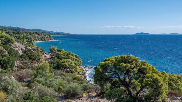 Wybrzeże Morza Egejskiego Grecji, skaliste wzgórza porośnięte drzewami i krzewami, rozległy obszar wodny
