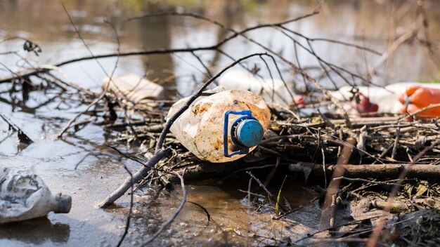 Wybrzeże rzeki zaśmiecone plastikowymi butelkami