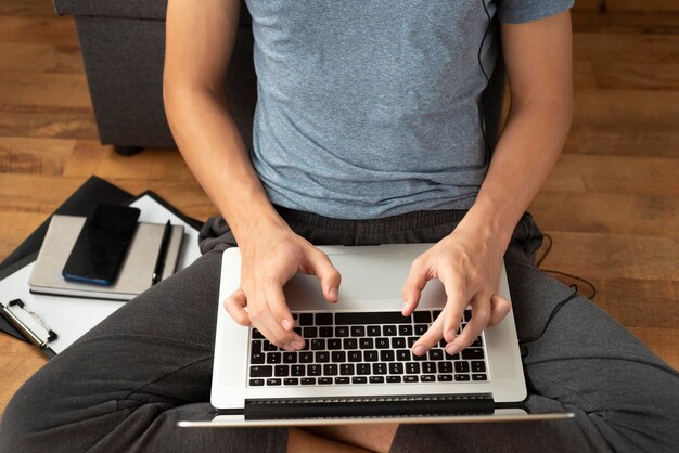 Wygodny mężczyzna poddany kwarantannie w domu za pomocą laptopa do pracy