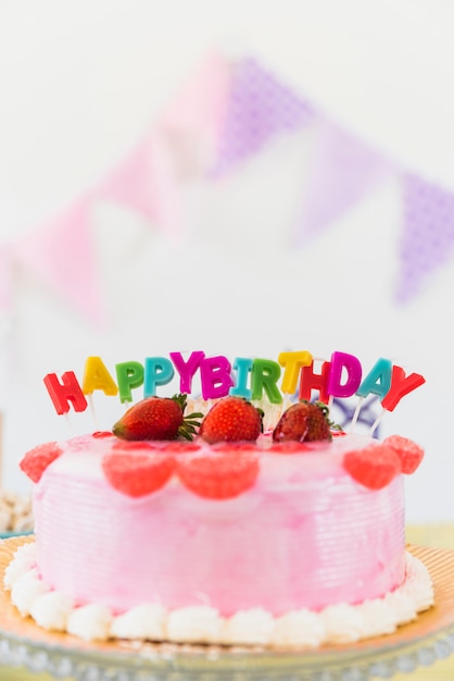 Bezpłatne zdjęcie wyśmienicie truskawkowy urodzinowy tort z kolorowymi świeczkami