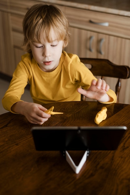 Bezpłatne zdjęcie wysoki kąt chłopca za pomocą tabletu w domu