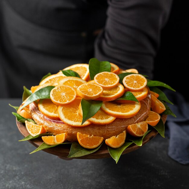 Wysoki kąt ciasta z plastrami pomarańczy i liśćmi