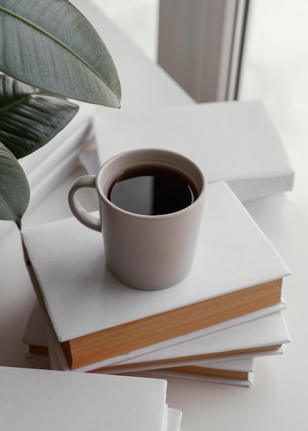Wysoki kąt filiżanka kawy na książkach
