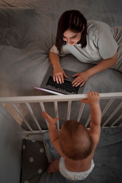 Wysoki kąt kobieta z dzieckiem pracuje na laptopie