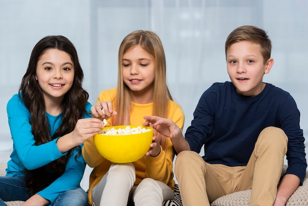 Wysoki kąt przyjaciół jeść popcorn