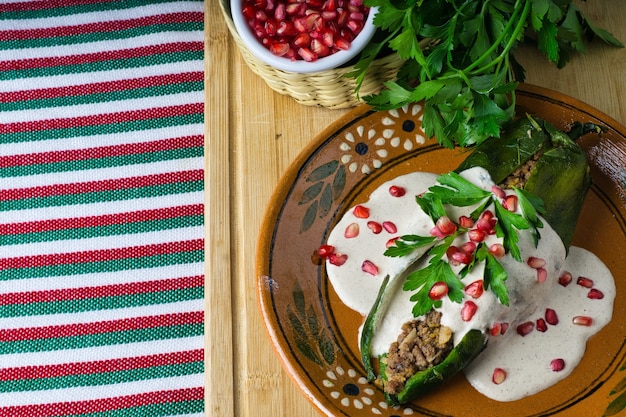 Wysoki Kąt Strzału Chiles En Nogada W Płycie Na Drewnianej Desce Na Stole