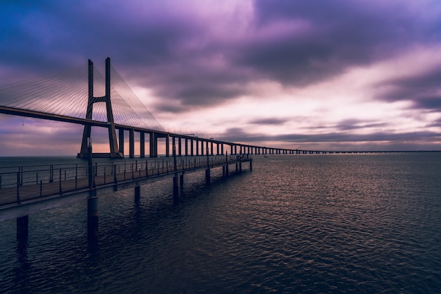 Wysoki kąt strzału drewniany most nad morzem pod fioletowym niebem