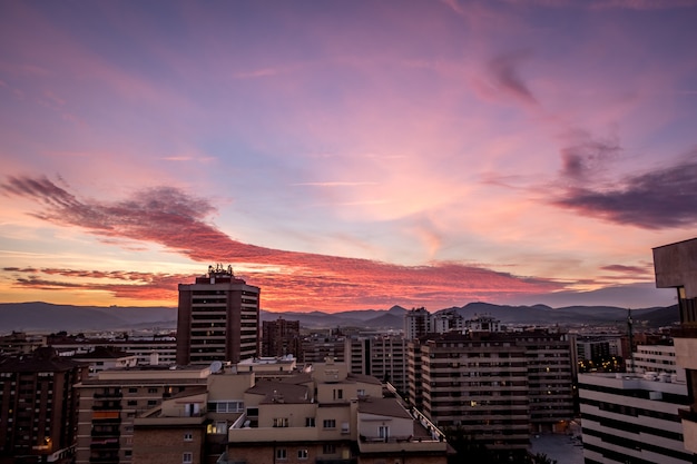 Wysoki kąt ujęcia budynków i pochmurnego nieba podczas zachodu słońca w Pampelunie, Hiszpania
