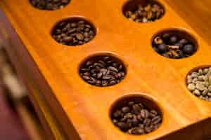 Bezpłatne zdjęcie wysoki kąt widzenia różnych ziaren kawy w drewnianym pojemniku