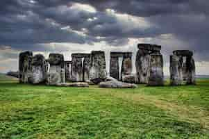 Bezpłatne zdjęcie wysoki kontrast ujęcia kamieni stonehenge w sailsbury uk w pochmurny deszczowy dzień z zieloną trawą