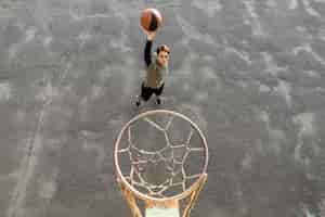 Bezpłatne zdjęcie wysoki widok mężczyzna rzuca koszykówkę