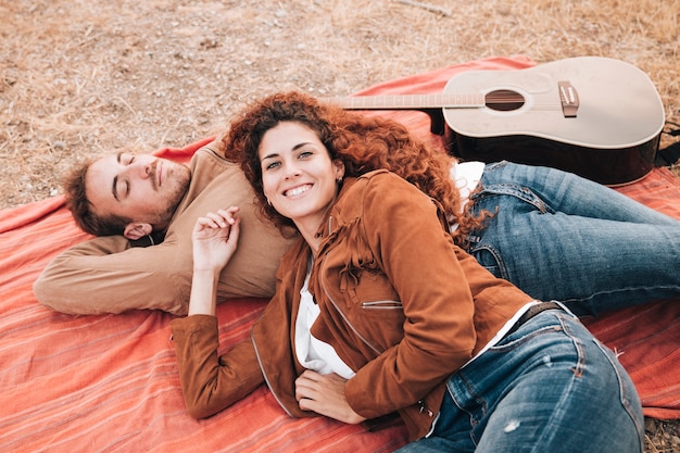 Bezpłatne zdjęcie wysoki widok pary lying on the beach na koc outdoors