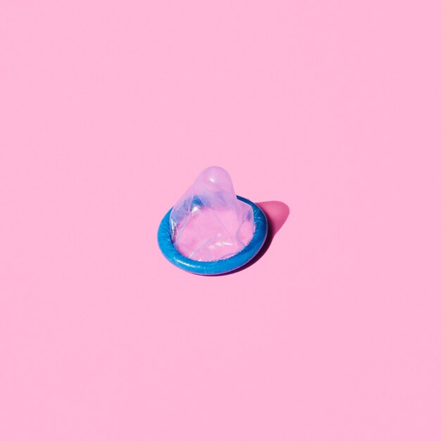Wysokiego kąta błękitny kondom na różowym tle