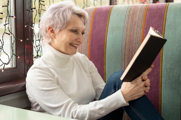 Bezpłatne zdjęcie wysokiego kąta smiley starszy żeński czytanie