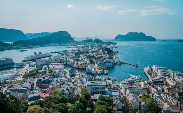 Wysokiego kąta strzał mnóstwo budynki na seashore blisko wysokich gór w Norwegia