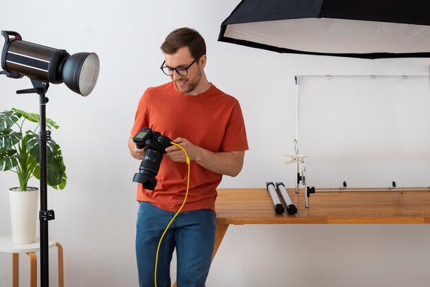 Wyspecjalizowany fotograf o średnim ujęciu pracujący w studio