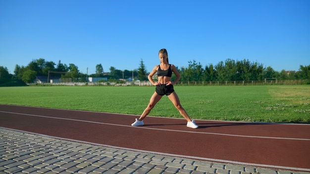 Wysportowana kobieta trenująca na stadionie na świeżym powietrzu