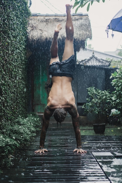 wytatuowany mężczyzna pozowanie w deszczu