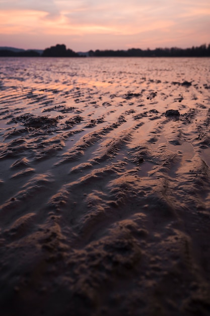 Wzór piasek przy niskim przypływem na plaży podczas zmierzchu