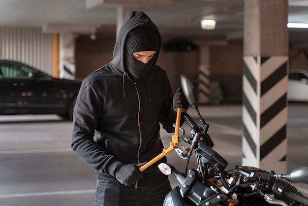 Z bliska mężczyzna przygotowujący się do kradzieży motocykla