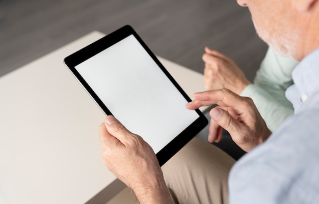 Z bliska mężczyzna trzymający tabletkę