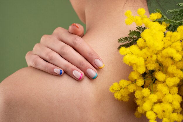 Z bliska piękny manicure i żółte kwiaty