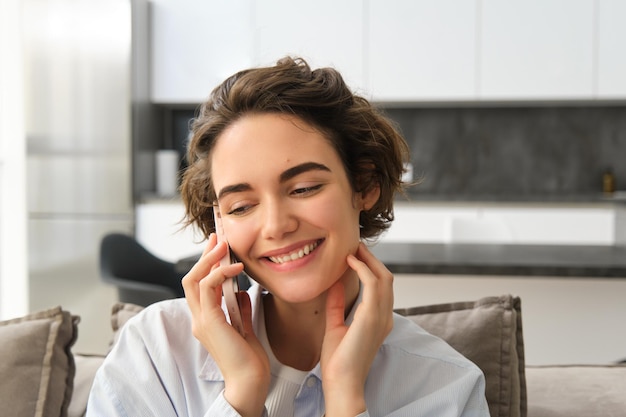 Z bliska portret szczęśliwej brunetki rozmawia przez telefon komórkowy na smartfonie, ktoś dzwoni