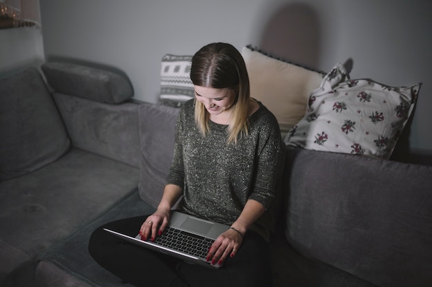 Bezpłatne zdjęcie z góry kobieta za pomocą laptopa na kanapie