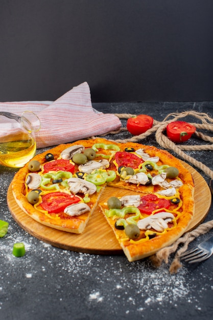 Z przodu daleki widok smaczna pizza grzybowa z pomidorami, zielonymi oliwkami i grzybami ze świeżymi czerwonymi pomidorami