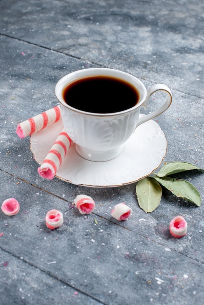 Z Przodu W Oddali Filiżanka Gorącej I Mocnej Kawy Wraz Z Różowymi Cukierkami Na Szaro