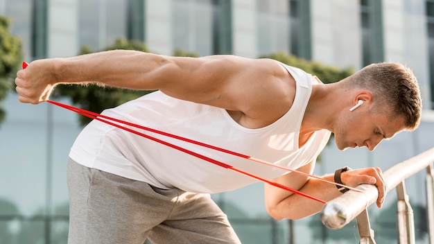 Bezpłatne zdjęcie z ukosa atletyczny mężczyzna trenuje outdoors