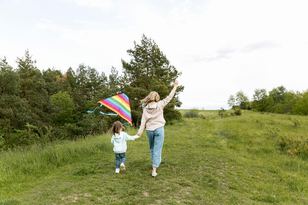 Za sklepem mama i dziecko bawią się latawcem