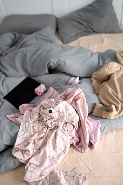 Zabałaganiona sypialnia pod wysokim kątem z ubraniami na łóżku