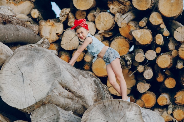 Zabawna dziewczyna stwarzających z drewna opałowego tle