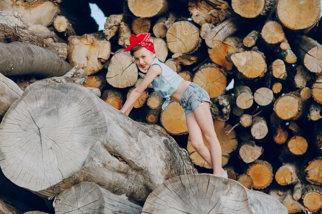 Zabawna dziewczyna stwarzających z drewna opałowego tle