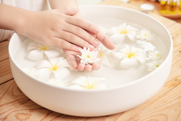 Zabieg i produkt uzdrowiskowy. białe kwiaty w ceramicznej misce z wodą do aromaterapii w spa.