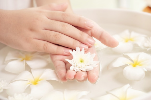 Zabieg i produkt uzdrowiskowy. białe kwiaty w ceramicznej misce z wodą do aromaterapii w spa.