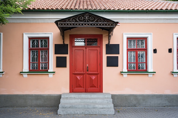 Zabytkowa architektura budynku klasycznej elewacji z czerwonymi drzwiami