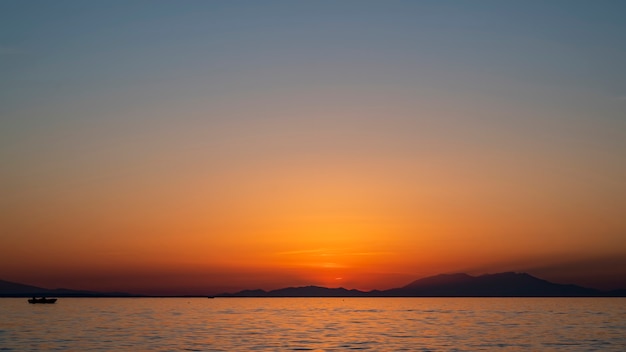 Zachód słońca nad Morzem Egejskim, statek i ląd w oddali, woda, Grecja