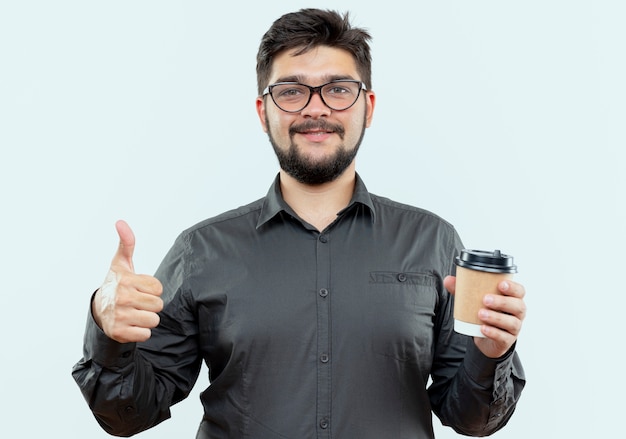 Zadowolony Młody Biznesmen W Okularach, Trzymając Filiżankę Kawy Kciukiem Do Góry Na Białym Tle