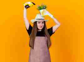 Bezpłatne zdjęcie zadowolony piękny ogrodnik dziewczyna ubrana w mundur i kapelusz ogrodniczy