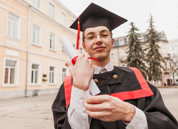 Bezpłatne zdjęcie zadowolony student z dyplomem