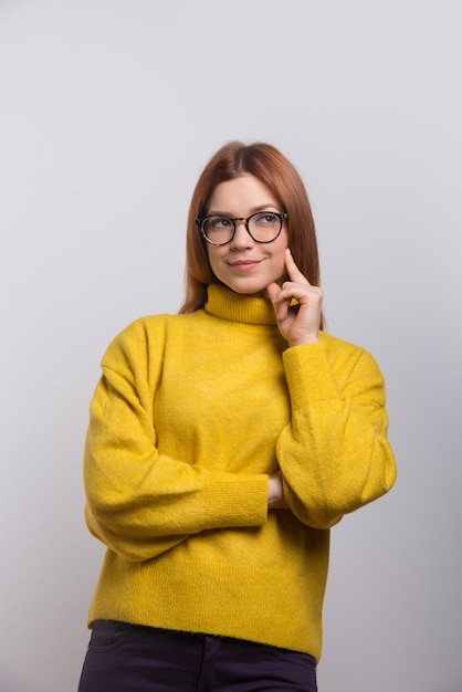 Zadumana młoda kobieta w eyeglasses przyglądający up